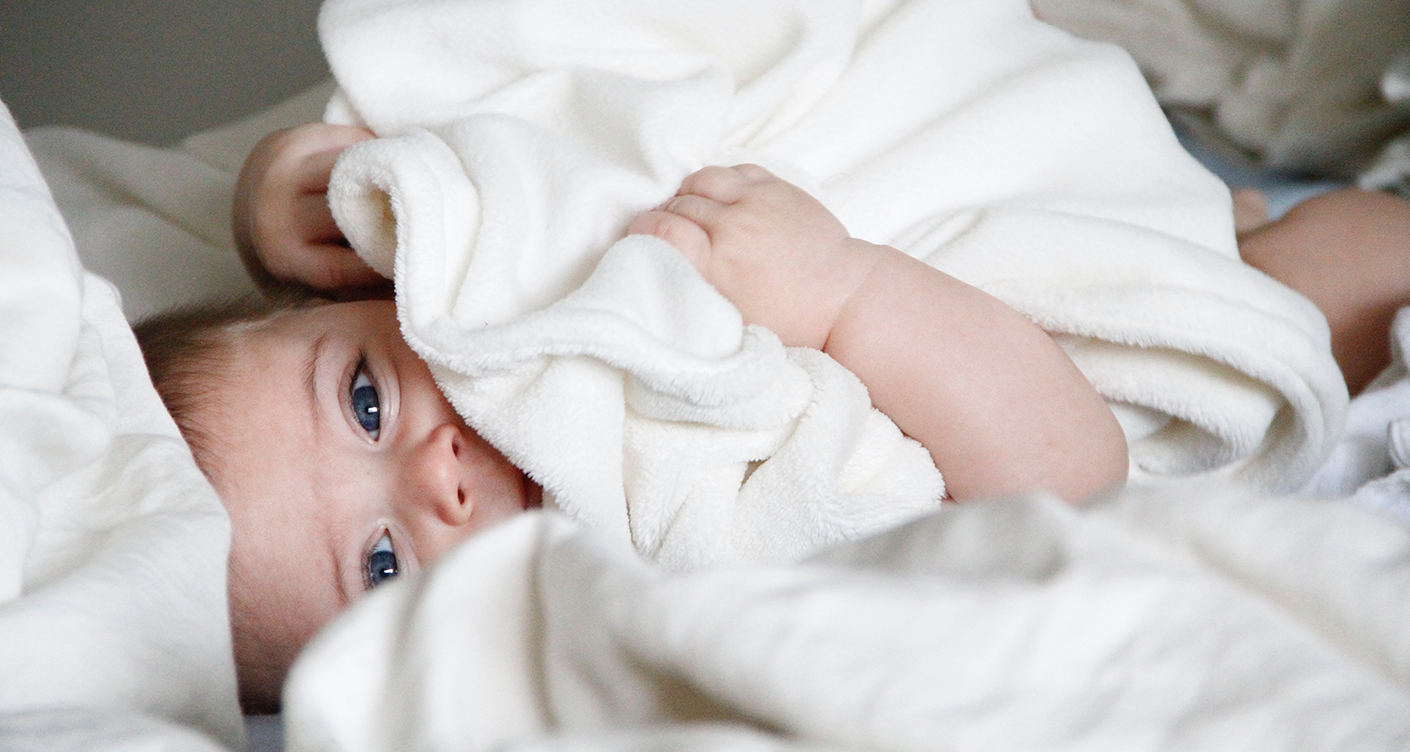 Baby mit Decke Bett