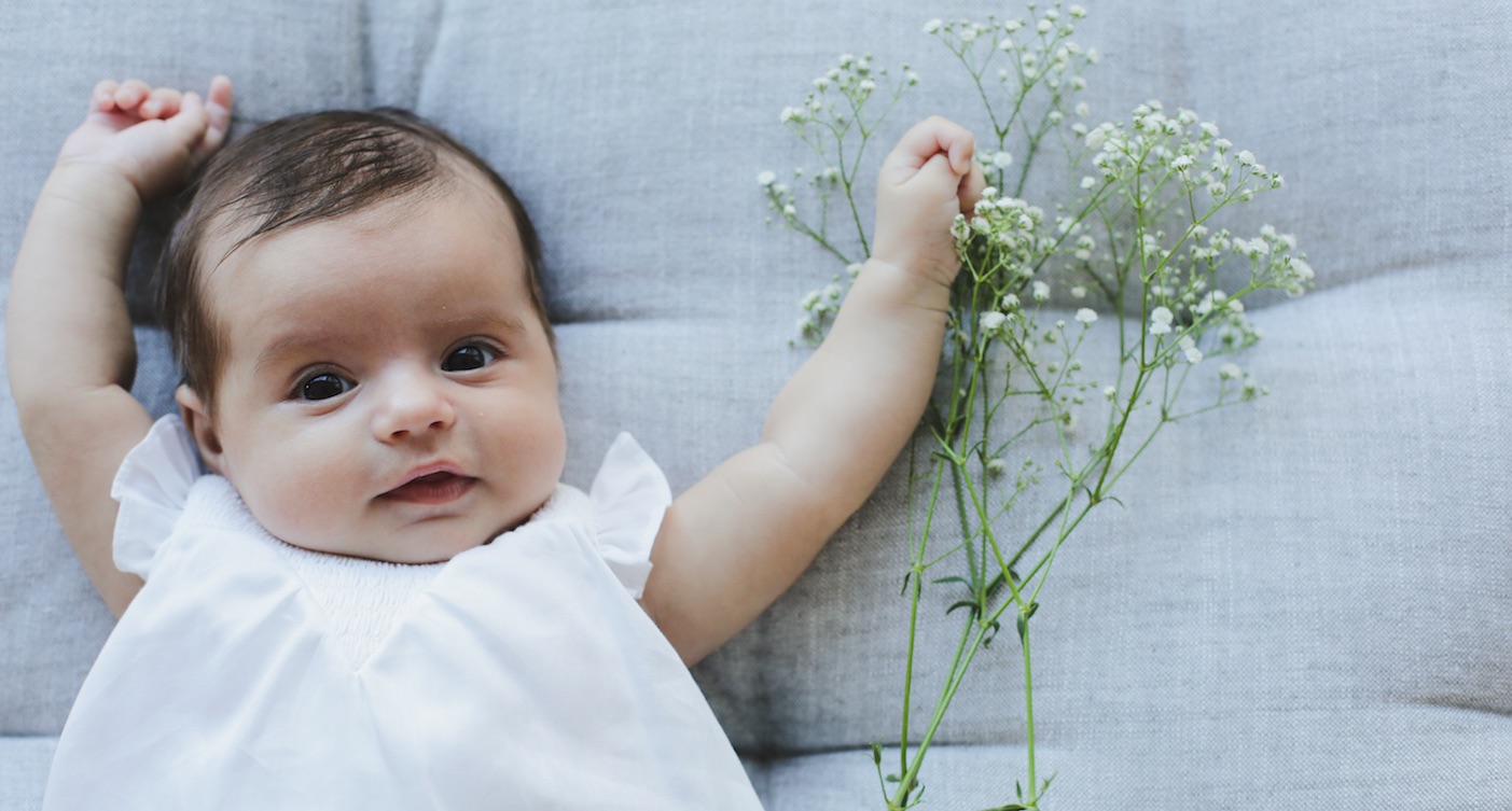 Taufe Knit Baby auf Sofa mit Blumen