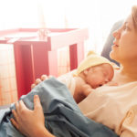 Frau mit Baby im Krankenhaus nach Kaiserschnitt